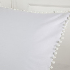 Een zacht wit kussen met vrolijke pompons, dat een gezellige sfeer toevoegt aan je interieur.