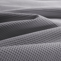 Close-up van een grijs dekbedovertrek met een luxe wafelpatroon, voor een stijlvolle uitstraling.