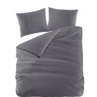 Een bed met twee kussens en een grijze dekbed, ideaal voor ontspanning en comfort in de slaapkamer.