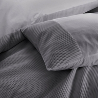 Dichtbijzicht van een bed met zachte kussens en een net opgemaakt laken, uitnodigend en comfortabel.