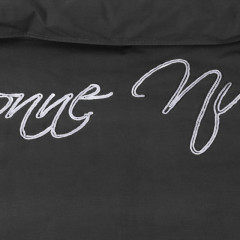 Close-up van zwart dekbedovertrek met opdruk 'bonne nuit', met een eigentijdse en stijlvolle uitstraling.