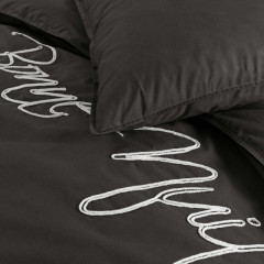 Een zwart bed met opvallende witte tekst, een trendy accent voor elke slaapkamerinrichting.