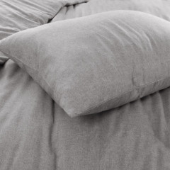 Close-up van een kussen op een bed, met een zachte stof en een rustgevende kleurstelling.