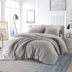 Een gezellige slaapkamer met een grijs dekbed op het bed, perfect voor ontspanning en rust.