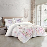 Slaapkamer met een wit bed en roze bloemenbedekking, biedt een frisse en uitnodigende sfeer voor een goede nachtrust.