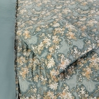 Een groen dekbed met een prachtig bloemdesign, dat een levendige sfeer aan elke slaapkamer toevoegt.