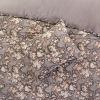 Een dekbed met een kleurrijk bloemenpatroon en een bijpassend kussen, ideaal voor een frisse en vrolijke uitstraling.