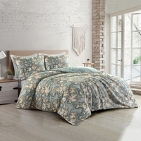 Een gezellige slaapkamer met een bed en een groen bloemen dekbed, perfect voor ontspanning en comfort.