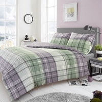 Een bed met een comfortabel dekbed in grijs en groen ruitpatroon, perfect voor een sfeervolle slaapkamer.