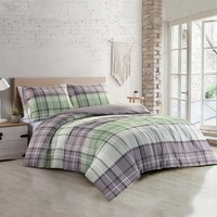 Een bed met een comfortabel groen-wit-grijs geruit dekbed, perfect voor een gezellige slaapkamer.