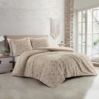 Slaapkamer met een wit bed en een beige dekbed, sfeervol ingericht voor een rustige uitstraling.