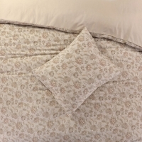 Een bed met een prachtig bloemenpatroon, dat een speelse en warme uitstraling aan de slaapkamer geeft.