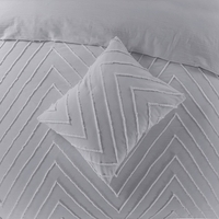 Een grijs bed met een chevronpatroon, dat elegantie en comfort in de slaapkamer brengt.