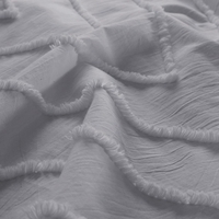 Detailopname van een grijze doek met franjes, die elegantie en verfijning uitstraalt.