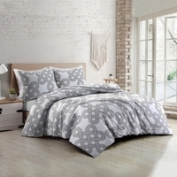 Slaapkamer met een wit bed en een grijze dekbed, sfeervol ingericht voor een stijlvolle uitstraling.