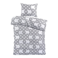 Een bed met een grijs en wit patroon dekbed, dat een moderne en stijlvolle uitstraling aan de slaapkamer geeft.