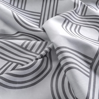 Wit en grijze stof met een geometrisch patroon, dat een moderne en stijlvolle uitstraling heeft.