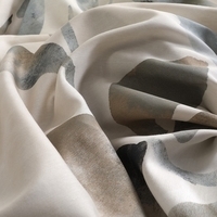 Close-up van een witte en grijze stof, met een zachte textuur en subtiele patronen die de kleuren mooi combineren.