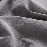 Detailopname van een grijze beddengoed, met een luxe uitstraling en een uitnodigende, zachte stof.