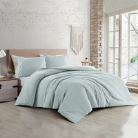 Een dekbed in een kalmerende lichtgroene tint ligt op een bed, perfect voor een ontspannen slaapkamer.