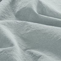 Detailopname van een lichtgroene bedlakens, rustgevend en fris.