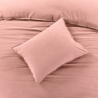 Een stijlvol roze bed met een kussen, dat een warme en gezellige sfeer uitstraalt.