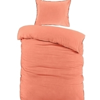 Een bed met een kussen en een oranje dekbed, een gezellige en warme slaapomgeving.