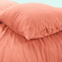 Close-up van een kussen op een bed, dat een gezellige en ontspannen sfeer uitstraalt.