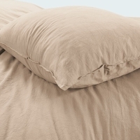 Close-up van een kussen op een bed, met zachte stoffen en een rustgevende kleurstelling.