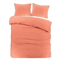 Een bed met twee kussens en een oranje dekbed, een gezellige en warme slaapomgeving.
