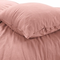 Close-up van een kussen op een bed, die samen een uitnodigende en comfortabele uitstraling creëren.