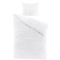 Een eenvoudig wit bed met een kussen en een witte dekbed, creëert een rustige en uitnodigende sfeer.