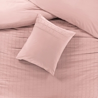 Een bed met een kussen en een zacht roze dekbed, perfect voor ontspanning en een gezellige slaapkamer.