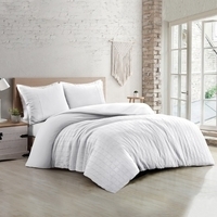 Een wit dekbedset op een bed in een moderne slaapkamer, met een rustige en uitnodigende uitstraling.