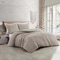 Slaapkamer met een zandkleurig bed op een houten vloer, sfeervol en uitnodigend ingericht voor een comfortabele sfeer.