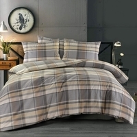 Een bed met een geruit dekbed en kussens, stralend van comfort en stijl in een sfeervolle slaapkamer.