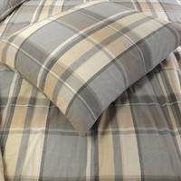  Een bed met een geruite dekbed en kussens, uitnodigend en comfortabel ingericht voor een gezellige sfeer.