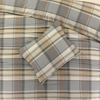 Een bed met een geruite dekbed en kussen, uitnodigend en comfortabel, klaar voor een goede nachtrust.