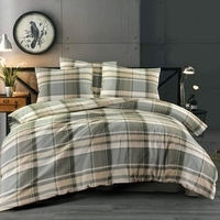 Een bed met een geruite dekbed en kussens, uitnodigend en gezellig ingericht voor een comfortabele nachtrust.