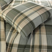 Een bed met een geruit dekbed en kussens, een sfeervolle en uitnodigende plek om te ontspannen en te slapen.