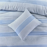 Blauw en wit gestreepte bedsprei met kussens, die samen een vrolijke en rustgevende slaapkamerlook vormen.