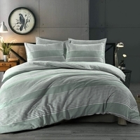 Een bed met een groen gestreepte dekbed en een wandklok boven het hoofdeinde.