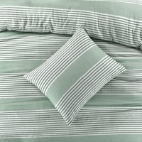 Een bed met een comfortabel groen-wit gestreept dekbed, perfect voor een gezellige slaapkamer.