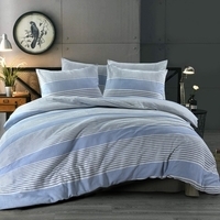 Een gestreept bed in blauw en wit, met een klok die de tijd aangeeft boven het nachtkastje.