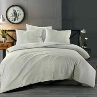 Een rustige slaapkamer met een lichtgroen dekbed en een wandklok, perfect voor een ontspannen sfeer en goede nachtrust.