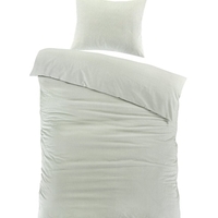 Een eenvoudig lichtgroen dekbed met twee kussens, stralend op een serene witte achtergrond.