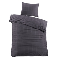 Een bed met een kussen en een zwart geruit dekbed, een warme en uitnodigende plek om te ontspannen en te slapen.