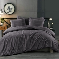 Slaapkamer met een grijs bed en een klok aan de muur, een uitnodigende ruimte voor comfort en ontspanning.