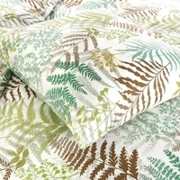 Een bed met een bladprint in groen en bruin, perfect voor een frisse en organische uitstraling in de slaapkamer.