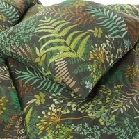 Een dekbed in groen en bruin, versierd met groene bladeren, dat een frisse en organische sfeer creëert.